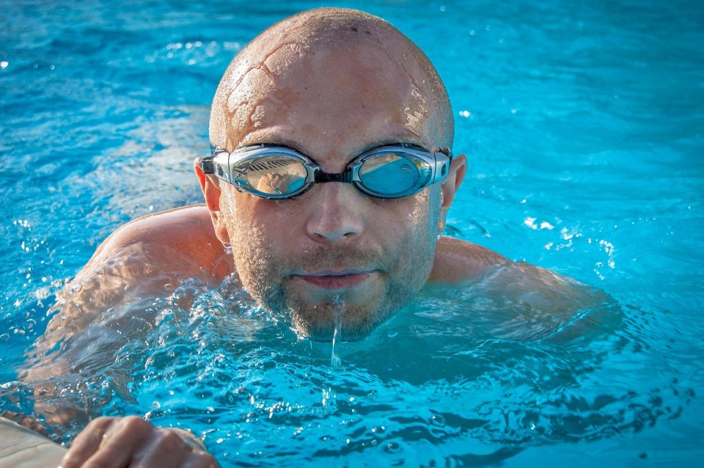 Homme qui sort la tête de la piscine